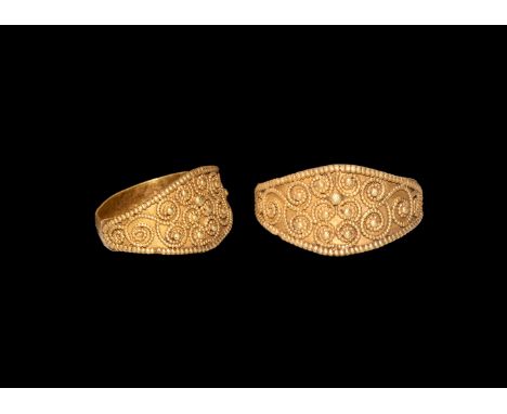 9th-11th century AD. A gold finger ring comprising a flat-section hoop, scaphoid bezel with beaded wire rim and scrolls with 