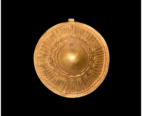 3rd-2nd millennium BC. A large sheet-gold pendant formed as a domed disc with rolled suspension loop, bands of repoussé pelle