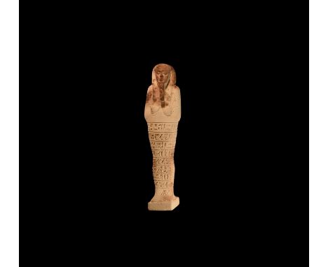 New Kingdom, 1550-1070 BC. A glazed composition shabti with tripartite wig and false beard, tools in the crossed hands and se