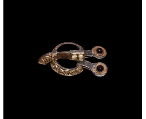 4th-5th century AD. A silver-gilt buckle set comprising: dished loop with chip-carved running scrolls to the outer face, trap