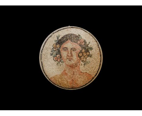 1st century BC-1st century AD. A discoid mosaic panel in a modern matrix with metal frame, depicting the facing bust of Bacch