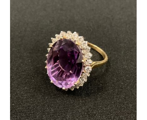 A diamond and amethyst cluster ring, large oval mixed cut amethyst approx 10.00ct, surrounded by a halo of round brilliant cu