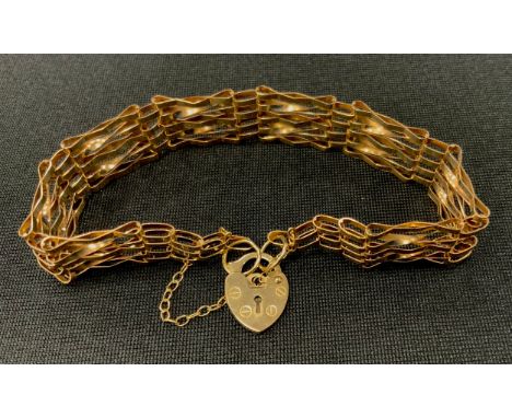 A 9ct gold twist bar gate bracelet, pad lock clasp, 1cm wide, 5.2g 