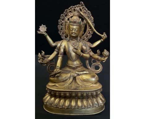 A Tibetan gilt bronze coloured metal Buddhistic figure, Bodhisattva seated, her six arms each holding different items, 23cm h
