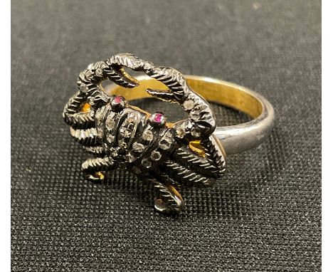 An unusual diamond novelty ring, as a crab, pave encrusted with rose cut diamonds, ruby eyes, total estimated stone weights, 