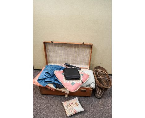 A suitcase containing curtains and cushions