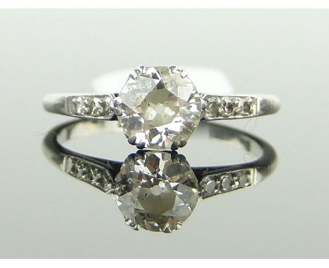 A platinum solitaire diamond ring, 
approx 0.8cts, with diamond set shoulders, size O.