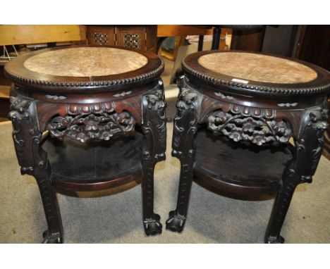 A pair of Chinese rosewood jardiniere stands,
having inset marble tops, ornate carved pierced frieze with shelf under on carv