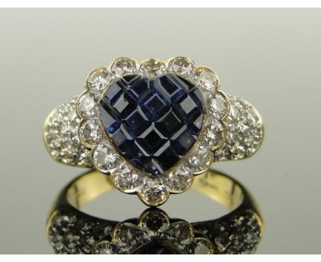 18ct gold heart shaped sapphire and diamond cluster ring,
the heart shaped setting having a calibre cut sapphire panel in 14 