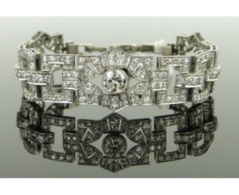 A fine Art Deco platinum and diamond bracelet circa 1930,
the articulated panels set with 3 large diamonds, largest approx. 1