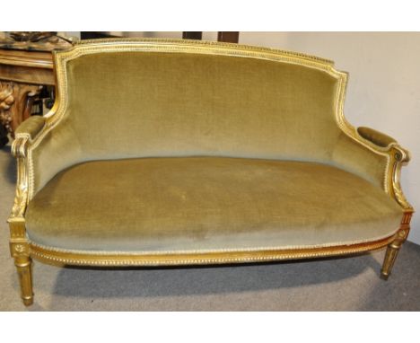 A continental carved gilt wood and upholstered salon sofa raised on fluted legs,
together with two similar armchairs.