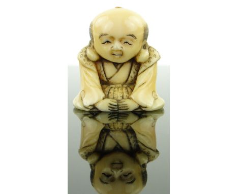 A late 19th century Japanese ivory netsuke
depicting a seated man, height 1.4".