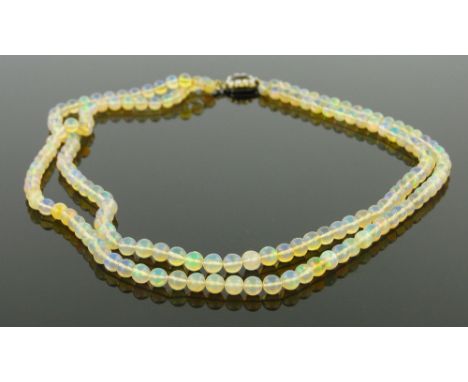 A double string polished opal bead necklace,
with garnet and pearl clasp.