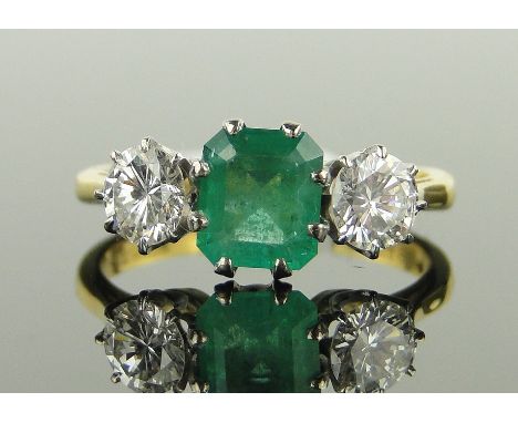 An 18ct gold 3-stone square-cut emerald and diamond ring,
emerald height 7mm, diamond content approx 1ct total, size N.