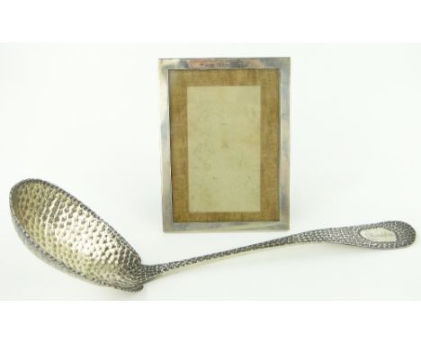 Unusual American hammered sterling silver ladle,
together with a sterling silver frame by Black, Starr & Frost, (2).