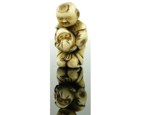 Late 19th century carved ivory netsuke
depicting a man with a baby, height 1.2".