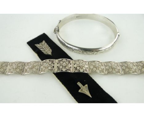 A paste set silver arrow design stickpin,
silver filigree bracelet and hinged bangle, (3).