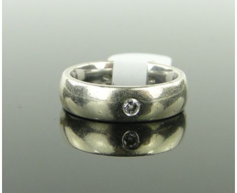 A 9ct white gold band ring 
set with a single diamond, 6g.