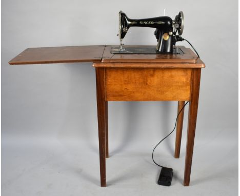 A Vintage Electric Singer Sewing Machine, Number Y5809414, with Power Lead and Foot Cable