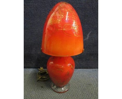 A signed continental red glass table lamp and matching shade with random line and gold leaf inclusions, on a clear glass foot