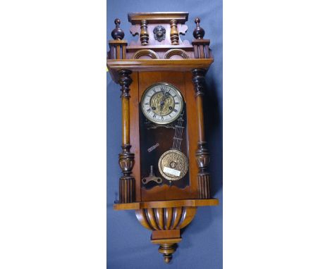 A COMPACT VIENNA WALL CLOCK with finial and mask pediment, labelled J. Saun, Mold