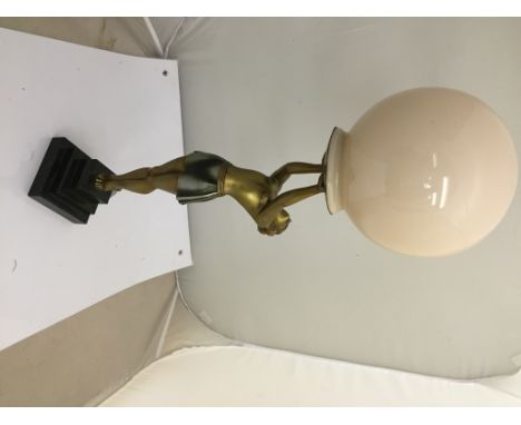 An Art Deco lady lamp carrying a ball on a marble stepped base