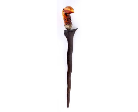 A South East Asian Kris, 19th Century with a 34cm wavy-blade and characteristic carved grip decorated with a naive eagle disp