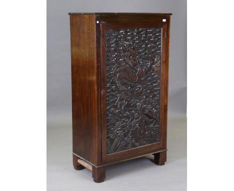 An early 20th century mahogany side cupboard, the door inset with a Chinese carved panel of two dragons within a surround of 