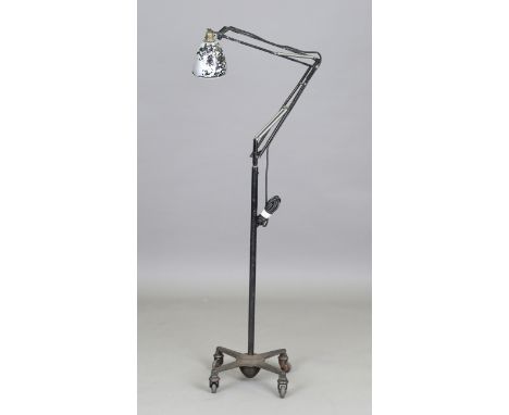An early 20th century anglepoise lamp standard by Herbert Terry, black painted and fitted with a metal shade, raised on four 