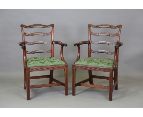 A set of eight early 20th century George III style mahogany pierced and carved ladder back dining chairs, comprising two carv