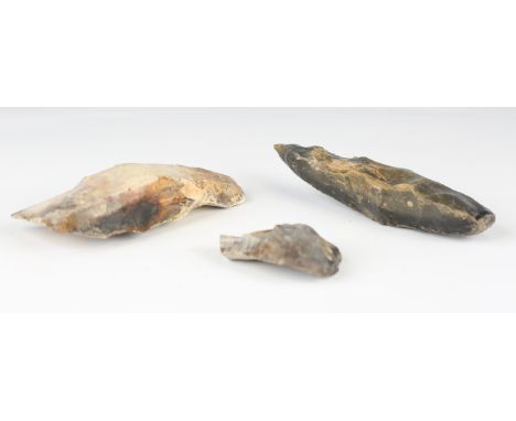 A Mesolithic fabricator tool, length 13.5cm, another crude axe head, length 13cm, and a scraper tool.Buyer’s Premium 29.4% (i