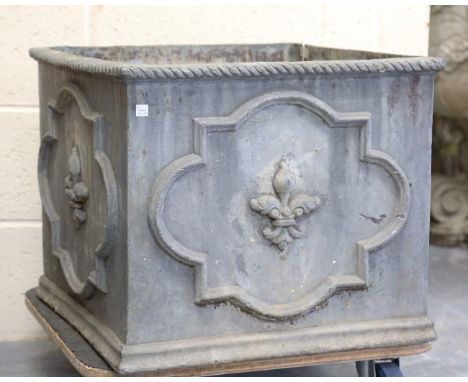 A 20th century lead garden planter of square section, each of the four sides relief cast with a fleur-de-lis and an heraldic 