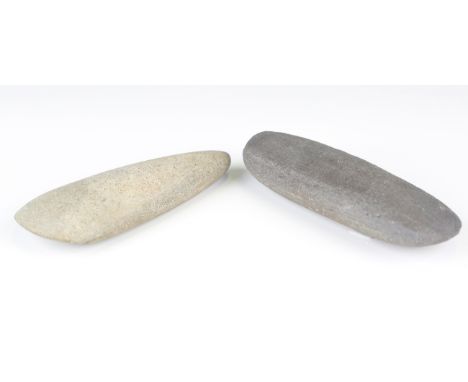 An ancient polished stone axe head, length 16cm, together with a similar example, length 16cm.Buyer’s Premium 29.4% (includin