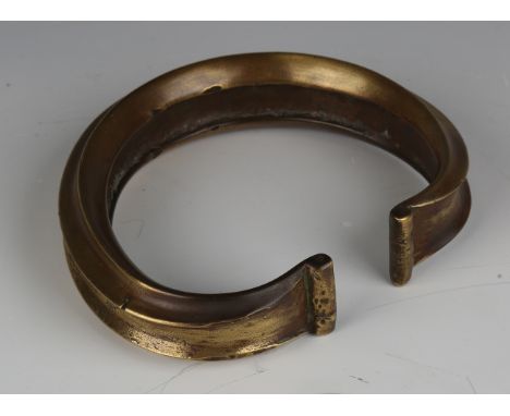 A large African bronze alloy bangle, probably Fulani tribe, Nigeria, width 15.5cm.Buyer’s Premium 29.4% (including VAT @ 20%)