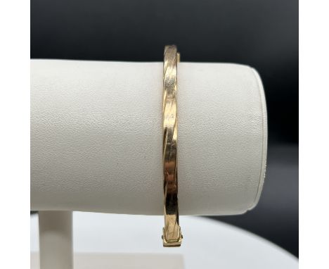 9ct yellow gold bangle,
box twist design with spring figure of 8 clasp,
weight 8.6 grams,
no metal inner core