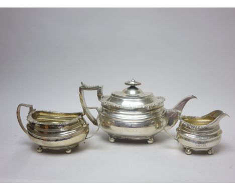 A George III/IV silver three piece Tea Service of boat shape with scallop, leafage and gadroon rims engraved initials on bun 