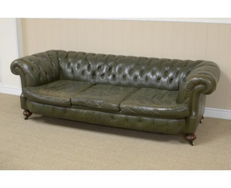 A green leather upholstered button back Chesterfield Sofa on bun feet and casters, stamped Holland & Co on rear right leg, 6f