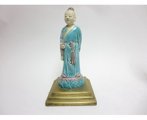 A Chinese famille verte biscuit Figure of the immortal Han XiangziLate 18th CenturyStanding in flowing turquoise robes and ho