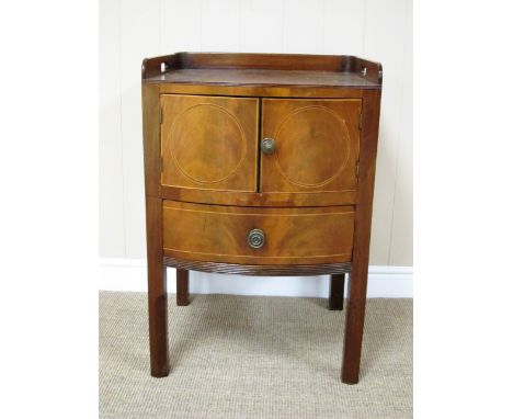 A George III mahogany bow front Bedside Commode with satinwood stringing having low gallery above pair of doors and drawer on