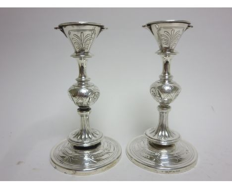 A pair of Tiffany & Co silver Candlesticks embossed three portrait masks to the knop stems on circular bases, 6 1/4in, No 620