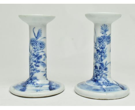 A pair of republic blue and white candle sticks. Each candlestick decorated with flowers and butterflies. Measures approx. 12