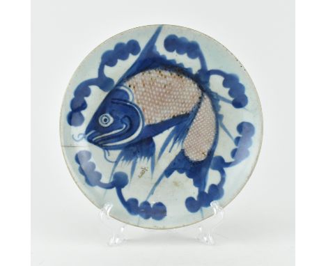 A Qing dynasty blue and white underglaze copper red Fish plate. The plate depicting a fish Koi Jinli surrounded by stylised s