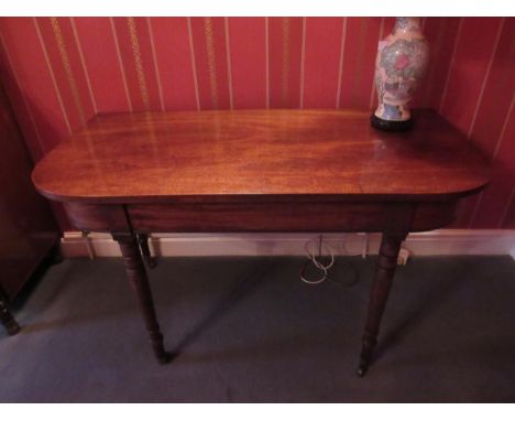 A George III mahogany side table with rounded corner top over ring turned tapering legs to castors, 122cm long 