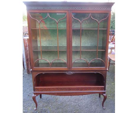 A mahogany cabinet, having a pair of glazed doors over a shelf, raised on cabriole legs, height 60ins, width 44ins, depth 13.