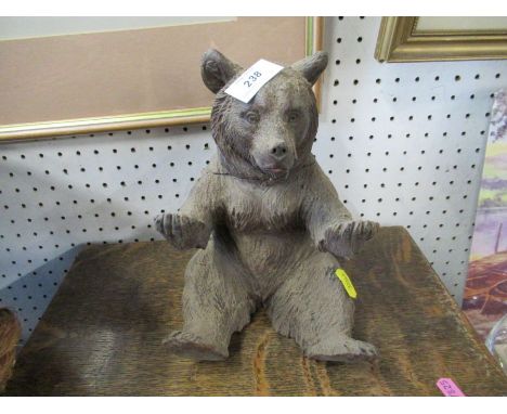 A Black Forest carved wooden bear inkwell, the seated model of a bear with hinged head revealing a glass inkwell
