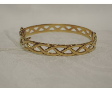 A 9ct gold hinged bangle having open twist style moulded decoration,  approx 12.4g
