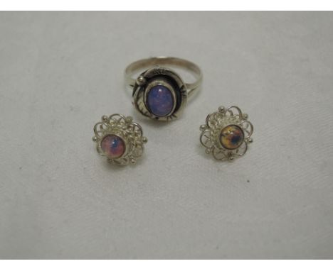 A pair of opal stud earrings in white metal filligree settings and an opal dress ring having leaf decoration to collared moun