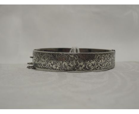 A 1930's  HM silver hinged bangle having floral and scroll decoration