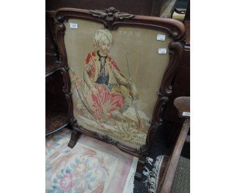 A mid Victorian rosewood frame firescreen having Berlin woolwork inset panel