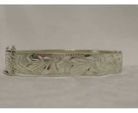 An HM silver hinged bangle having engraved decoration and twist clasp,  approx 23.9g